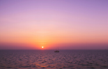 Obraz premium Sunset and Lonely Boat on the Sea