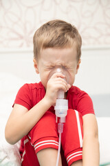 Sad little boy sitting in red t-shirt and almost crying, breathing nebulizer