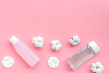 mycelial water, lotion and cotton pads for skin care on pink background flat lay space for text