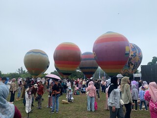 Colorful hot air balloons festival display distinct horizontal stripes are being inflated on the...
