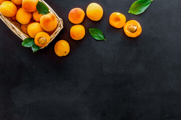 Collect apricots, black background top view space for text, pattern with leaves