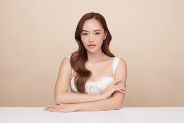 A beautiful young Asian woman with clean, fresh skin against a beige background. Skincare, facial...