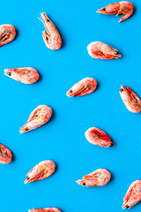 Shrimps - frozen - pattern on blue background top view