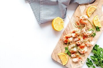 Shrimp skewers - appetizer in mediterranean kitchen - on white table top view copy space