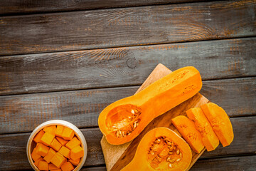 Pumpkin - slices on cutting board - on wooden background top-down space for text