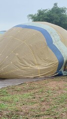 Colorful hot air balloons festival display distinct horizontal stripes are being inflated on the cloudy sky provide  backdrop. 