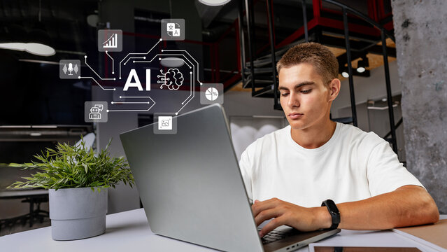 Young man engages in artificial intelligence project while working on a laptop in a modern office space during the day