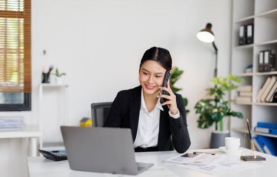 Young business asian woman thinking on phone while working in the office 
 - Powered by Adobe