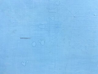 Blue painted wall with water stains and textured surface