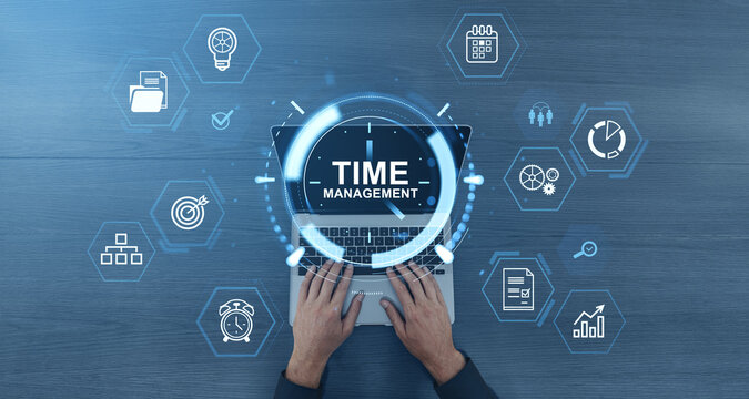 Time management concept with digital interface icons over laptop and hands typing on keyboard on blue wooden background.