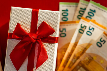 Gift Box with Euro Banknotes.Gifts and Euro Currency on Red Background.Euro Banknotes on Top of Red...