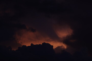 Toma de lejos de unas bellas nubes de color naranja o rojo en un cielo de color azul durante el atardecer