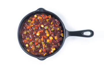 Mexican chilli beans with vegetables in iron pan isolated on white background. Top view