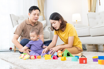 Asian family mother,father ,son playing with colorful kid toys. Happy baby boy in kindergarten or...