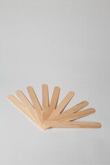 Several wooden disposable cosmetic spatulas for wax depilation or sugaring on white background. Beauty procedures, skin care. Copy space