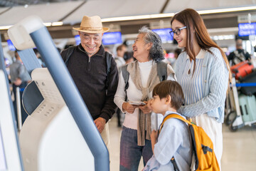 Asian family using airport self check-in kiosk together, multigenerational group interacting with digital screen, modern travel process with child exploring, technology and convenience for travelers