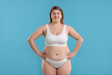 Naklejka premium Weight loss. Plus size woman in underwear on light blue background