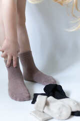 Baby feet in warm brown socks on a white background