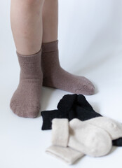 Baby feet in warm brown socks on a white background