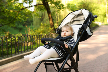 Cute little baby in stroller at park. Space for text