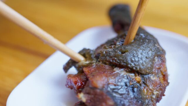 Close-up of braised native chicken used as topping for Yunnan-style rice noodles&mdash;highlighting deep color, glossy skin texture, and the savory richness of ethnic soup ingredients.