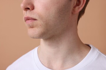 Man after shaving on beige background, closeup