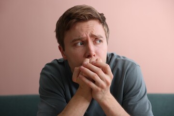 Scared man suffering from paranoia at home