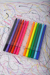 Multicolored marker or fine liner pens in plastic case on paper background. Art tools