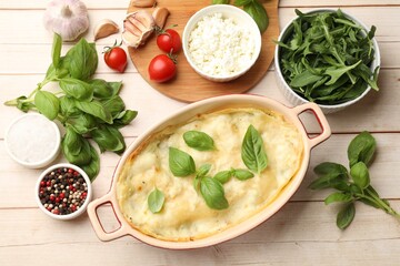 Tasty vegetarian lasagna and ingredients on wooden table, flat lay