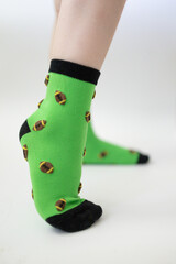 Baby feet in bright green socks on white background