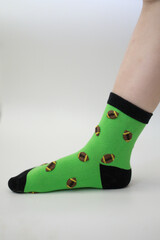 Baby feet in bright green socks on white background