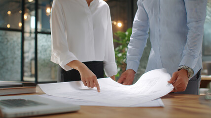 二人のアジア人が書類を確認するオフィス場面