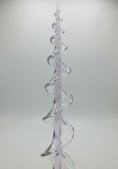 Iridescent glass spiral sculpture in soft pastel light minimalist abstract art vertical shot
