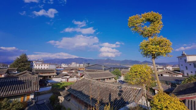 Traditional residential rooftops in Lijiang unfolds with shifting light&mdash;showcasing tiled roofs, carved wood structures, and a serene mountain backdrop that blends heritage and everyday