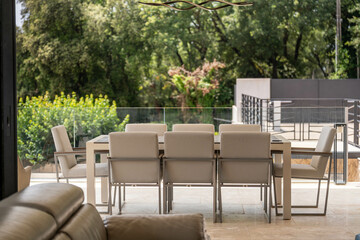 Salle à manger extérieure moderne entourée de verdure