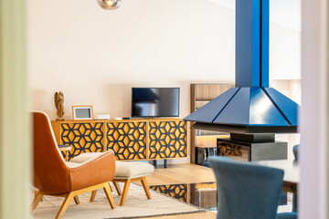 Salon moderne avec cheminée centrale bleue et enfilade géométrique