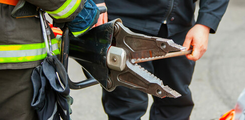 Firefighter uses hydraulic tool to rescue trapped individual during emergency response in urban area