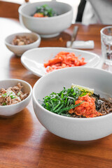 Traditional Korean meal - bibimbap with buckwheat noodles, carrots, tea, snacks in a restaurant 