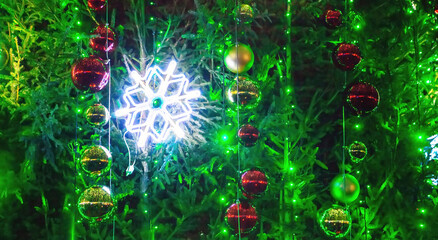 Festive decorations with colorful lights and ornaments on a green tree during the holiday season
