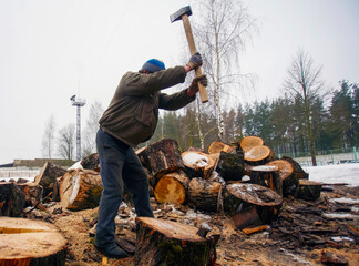 Man chopping firewood in a snowy landscape during winter