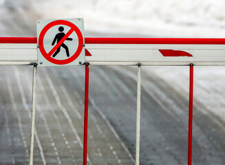Barrier preventing pedestrian access on a snow-covered street in an urban area during winter
