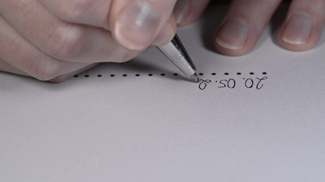 Sign the contract up close, date and signature written in pen on paper