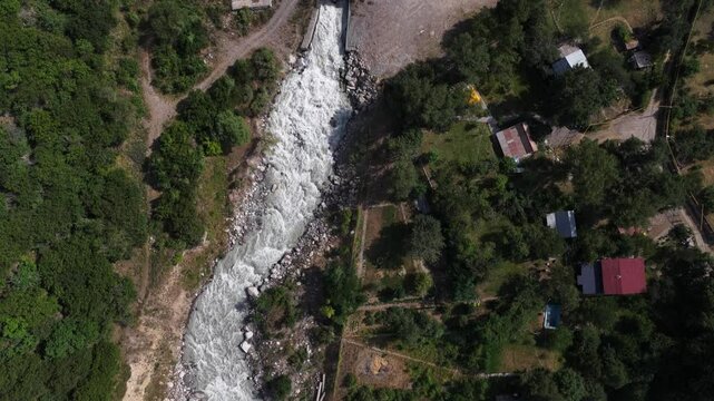 A protective dam against mudflows. Talgar gorge, Tian Shan Mountains. Different vegetation and a mountain river. The view from the drone.