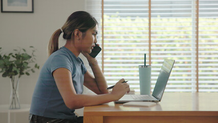 Young adult Gen Z people black asia woman busy phone call work at home using laptop AI search data...