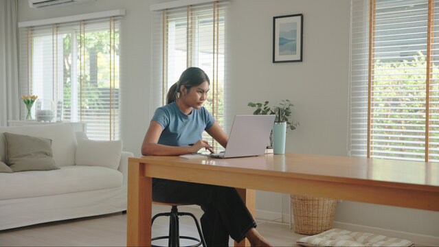 Young adult Gen Z people black asia woman happy busy work at home office using laptop AI search data hybrid workplace. Stock trade IT reskill upskill asian cyber typing coding. Online income tax apply