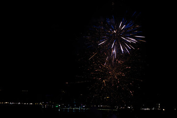sparkling blue and golden fireworks over city lights