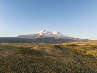 Fototapeta premium Beautiful Mount Shasta volcano with snow and glacier visible, in early summer morning sunlight, aerial view