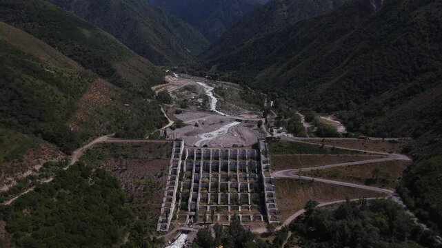 A protective dam against mudflows. Talgar gorge, Tian Shan Mountains. Different vegetation and a mountain river. The view from the drone.