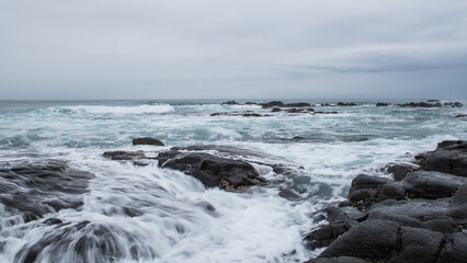Seascape image taken on the South African coastline with rocks in foreground