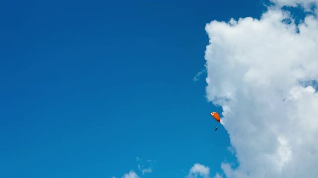 Man paragliding over coastal cliffs on a sunny day.
